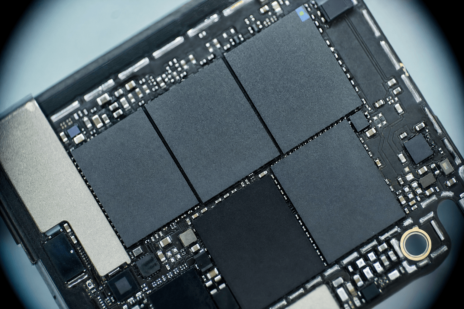 Smartphone logic board under microscope showing NAND flash memory chips
