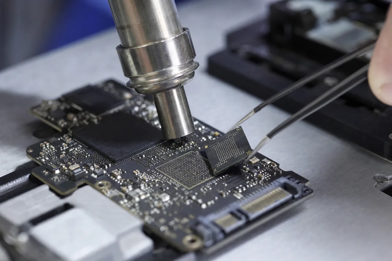 A NAND flash chip removed from a board for chip-off recovery, its BGA pads cleaned and prepared for reading in a precision socket